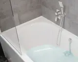 Nowoczesna łazienka z wanną i prysznicem. Woda leje się do wanny, tworząc bąbelki.