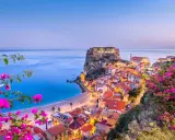 Scilla, Calabria: un borgo da sogno dove andare al mare, con il castello Ruffo a picco sul blu e fiori colorati.