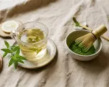 Préparation du matcha pour profiter de ses bienfaits. Thé vert, citron et herbes fraîches sur fond de lin.