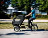 Mann fährt ein Lastenrad mit Kabine, ideal für lastenrad erwachsene transportieren.