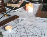 Świece i kadzidełka tworzą mistyczną atmosferę wokół kart astrologicznych. 11 dom astrologia w centrum uwagi.