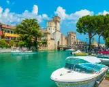 Malowniczy rejs po Jeziorze Garda. Woda lśni, a zamek Scaligero w Sirmione zaprasza do zwiedzania.