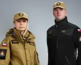 Kobieta i mężczyzna w nowych mundurach PSP: piaskowa kurtka i czarna bluza.
