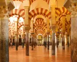 Ein Saal mit Säulen und roten und weißen Bögen, der an die Gelehrsamkeit arabischer Wissenschaftler erinnert.