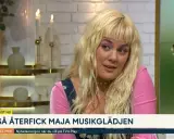 Maja Francis, med sitt blonda hår och rosa tröja, pratar om hur hon återfick sin musikglädje. En gitarr syns i bakgrunden.