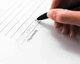 Dłoń podpisuje dokument. Czy to umowa, czy może coś innego? To jest wexel, co to jest?