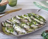 Deliciosas sardinas al horno, cubiertas con una sabrosa salsa verde, listas para disfrutar.