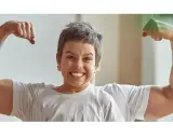 Chłopiec z miną jak po **buncie 5 latka** pokazuje swoje małe bicepsy, podczas gdy za nim widać potężne ramiona taty.