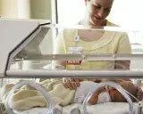 Pielęgniarka opiekuje się dzieckiem urodzonym w 32 tygodniu ciąży w inkubatorze.