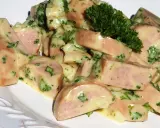 Une délicieuse salade de cervelas, coupée en dés et nappée d'une sauce crémeuse aux herbes fraîches, garnie d'un brin de persil.