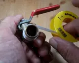 Main tenant une vanne, il applique du ruban de téflon pour assurer une étanchéité parfaite.