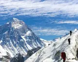 Alpinisci wspinają się na ośnieżony grzbiet, zbliżając się do jednego z najwyższych szczytów kontynentów.