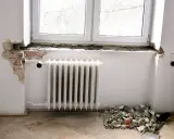 Rozpoczęła się wymiana parapetu wewnętrznego. Widać gruz pod oknem i odsłoniętą cegłę.