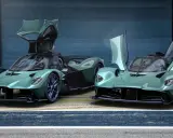 Zwei Aston Martin Valkyrie Spider in Mintgrün mit geöffneten Flügeltüren stehen nebeneinander.