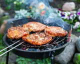 Saftige Steaks brutzeln auf dem Grill. Das Aroma von gegrilltem Fleisch liegt in der Luft.