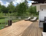 Träaltan med solstolar och grill. För att bevara träets skönhet, fundera på hur ofta olja altan.