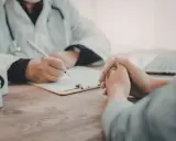 Consultation médicale : un médecin note des informations sur une liste maladie professionnelle secrétaire.
