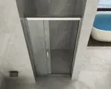 Doccia angolare con porta scorrevole in vetro. La nicchia doccia è rivestita in marmo grigio, con una vasca da bagno sullo sfondo.