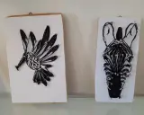 Två spik tavlor med djurmotiv: en kolibri och ett zebrans huvud, skapade med tråd och spik.