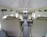 Innenraum einer DHC-6 Twin Otter mit bequemen Ledersitzen und Blick auf das Cockpit.