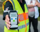 Policjant pokazuje alkomat z wynikiem 0.93 promila. Kontrola trzeźwości to ważny element bezpieczeństwa na drogach.