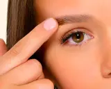 Un doigt applique un produit sur un sourcil, montrant a quoi servent les sourcils : protéger les yeux et exprimer les émotions.