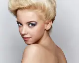 Mujer joven con peinado voluminoso y maquillaje llamativo, sus ojos de bambi cautivan la mirada.
