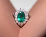 Anello con smeraldo ovale circondato da diamanti, un gioiello di grande valore, più prezioso di un rubino.