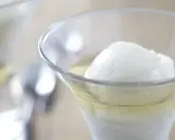 Une boule de sorbet citron dans un verre rempli de Calvados. Une recette de trou normand pour un dessert rafraîchissant.