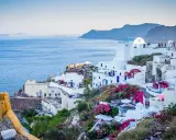 Białe domy na zboczu klifu z widokiem na morze, Santorini, Grecja.