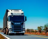 Camión Scania blanco en carretera soleada. Pensando en el coste del carnet de camión para conducir este gigante.