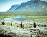 Vandring i **Laponia nationalpark** med fjäll, sjö och skog. En grupp vandrare njuter av den storslagna naturen.