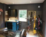 Snygga garage med cyklar upphängda, verktygsskåp och en bil. Perfekt garage inspiration för den som gillar ordning och reda.