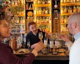 Två personer njuter av en ölprovning i Stockholm. En glad bartender serverar.