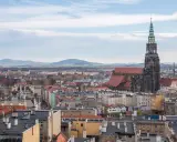 Widok na miasto z dominującą wieżą katedry. W oddali góry. Odkryj **Świdnica atrakcje**!