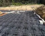 Preparación para un forjado sanitario ventilado: se aprecian los casetones negros y la malla metálica sobre ellos.