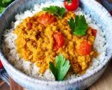Herzhaftes rote Linsen Curry mit Reis, garniert mit frischer Petersilie und Kirschtomaten. Ein Genuss für die Sinne!