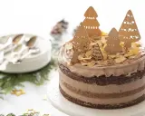 Gâteau au chocolat décoré d'arbres de Noël en bois, d'amandes effilées et d'un lapin.