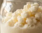 Milch-Kefir-Kulturen in einem Glas, bereit zur Fermentation. Diese lebenden Organismen wandeln Milch in ein probiotisches Getränk um.
