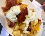 Un plato de patatas fritas con huevos escalfados y jamón, típico de los furanchos de Pontevedra.