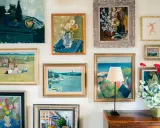 A gallery wall showcasing a diverse collection of paintings, proving that collecting art on a budget can create a vibrant and personal space.