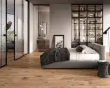 Modern bedroom with glass doors, a bed, and a wardrobe. The doors are designed to transform a hinged door into a sliding one, saving space.