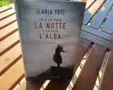 Copertina del libro "Ed è un poco la notte e un poco l'alba" di Ilaria Tuti, con una figura femminile su uno sfondo nebbioso.
