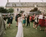 Novia con ramo de flores, rodeada de mujeres con cintas blancas, en el momento cuando se tira el ramo de novia.
