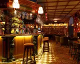 Mysig bar med bokhyllor och bekväma sittplatser, perfekt för att upptäcka Stockholms bästa barer.