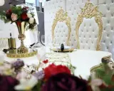 Elegancki stół z kwiatami i złotymi zdobieniami. Zastanawiasz się, ile się płaci za ślub cywilny w takim otoczeniu?