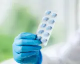 Ręka w niebieskiej rękawiczce trzyma opakowanie niebieskich tabletek. To może być alternatywa dla naturalnych suplementów na potencję.