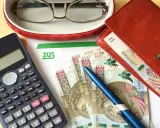 Kalkulator, pieniądze i dokument ZUS sugerują analizę podwójnych emerytur dla wdów.