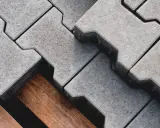 Szare kostki brukowe ułożone na drewnianej palecie. Zastanawiasz się, ile kosztuje metr kostki brukowej?