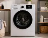 Pralka Samsung z błędem DC. Obok kosz z praniem i regał z ręcznikami.